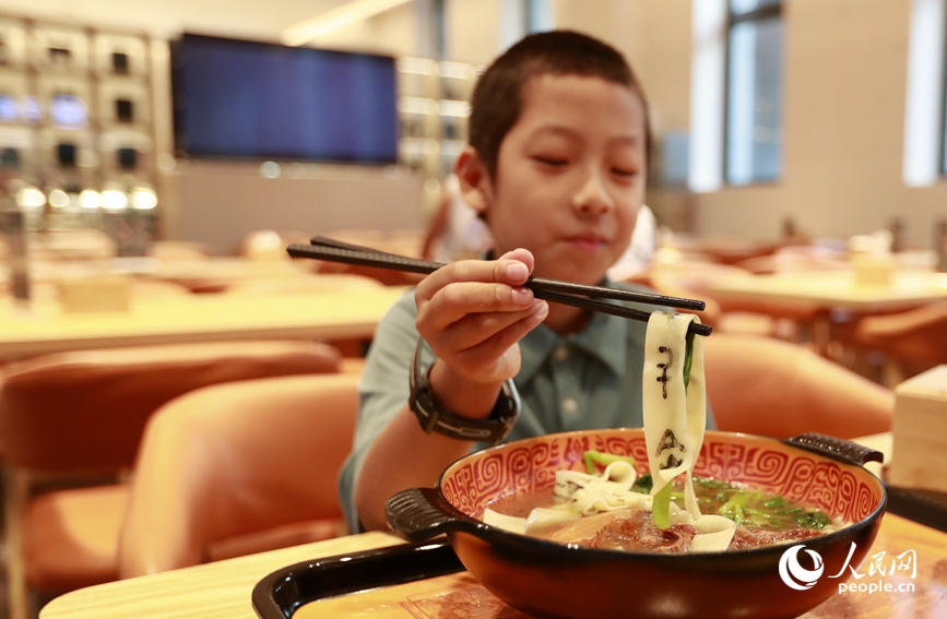 殷墟博物館推出的甲骨文面深受游客喜愛。人民網(wǎng)記者 慎志遠(yuǎn) 攝